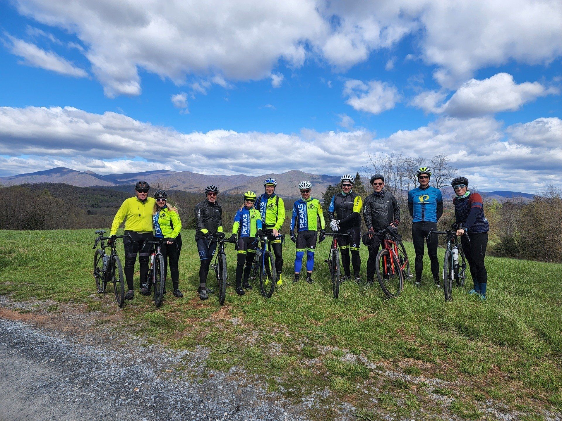 A group of people standing next to each other on bicycles in a field.