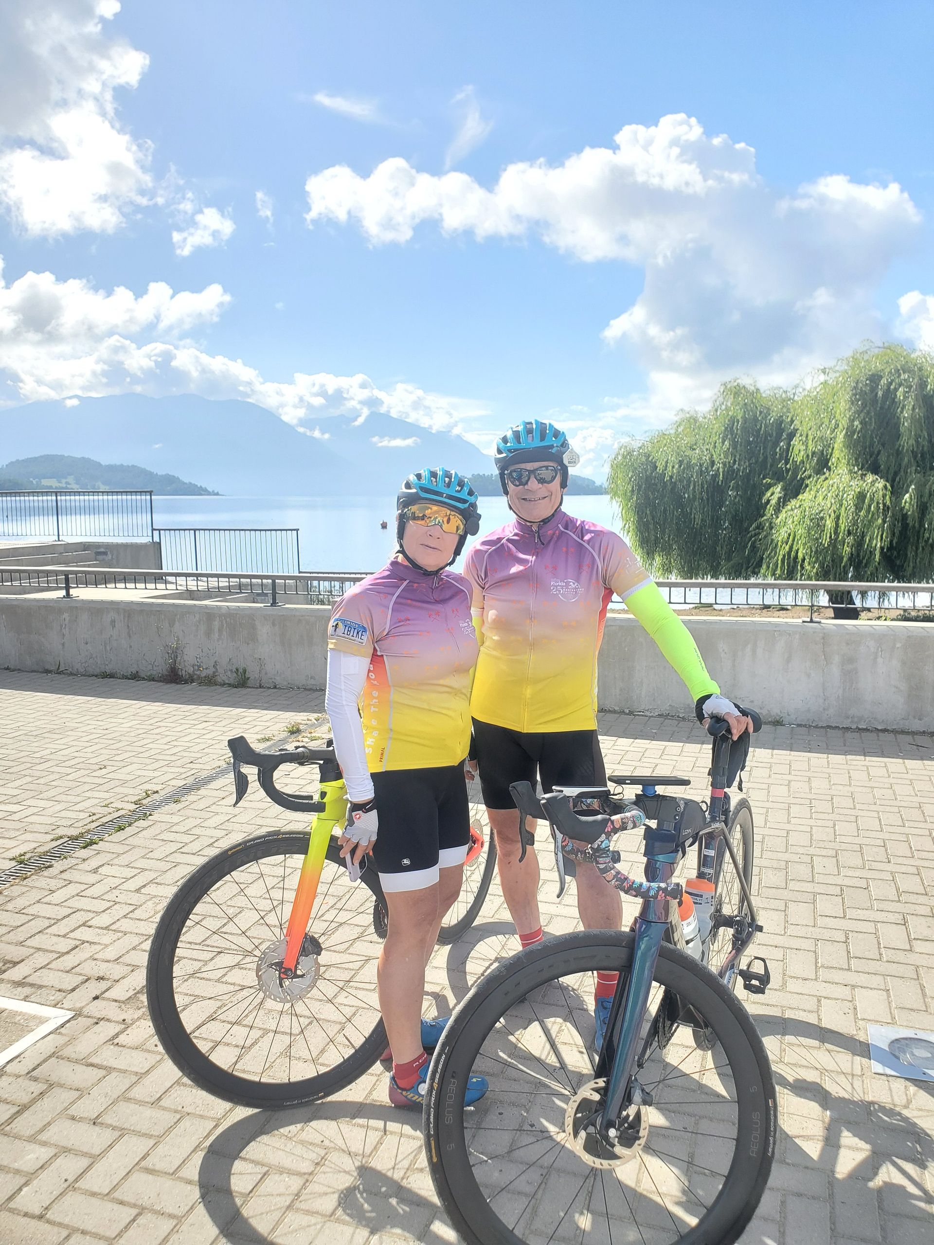Two people are standing next to each other with bicycles.