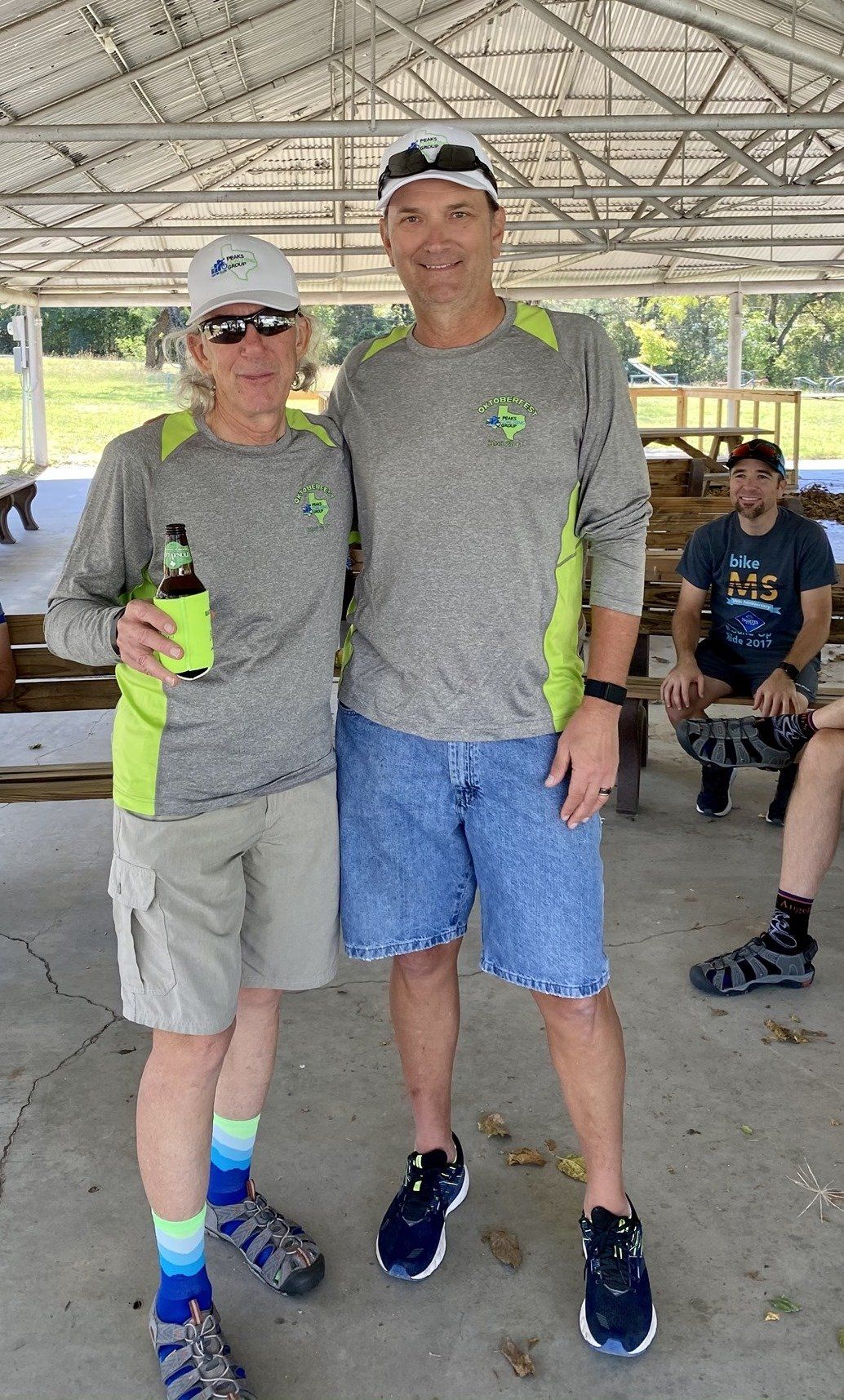 Two men are standing next to each other under a canopy.