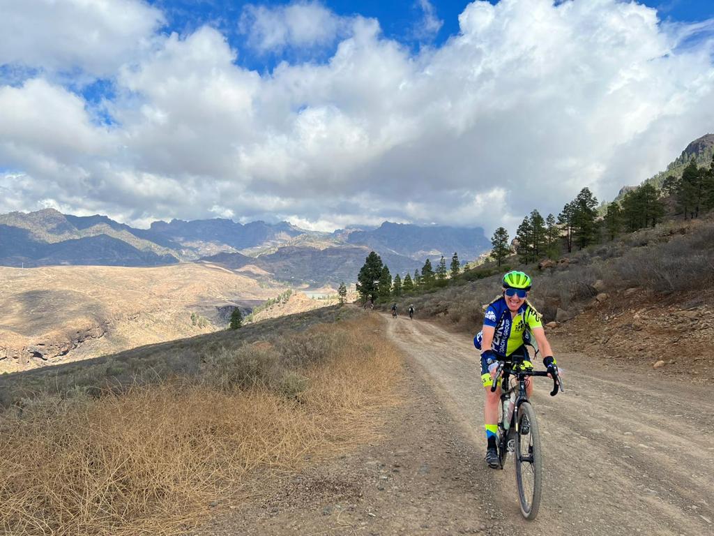 A person is riding a bike down a dirt road.