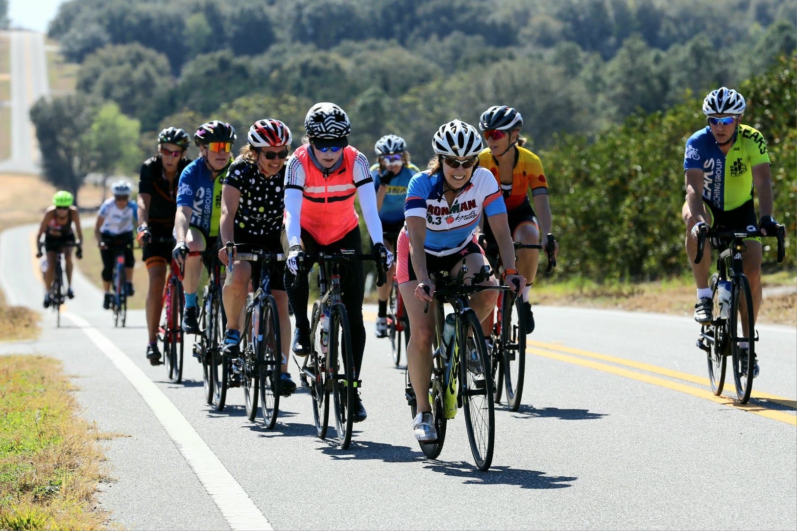 A group of people are riding bicycles down a road.