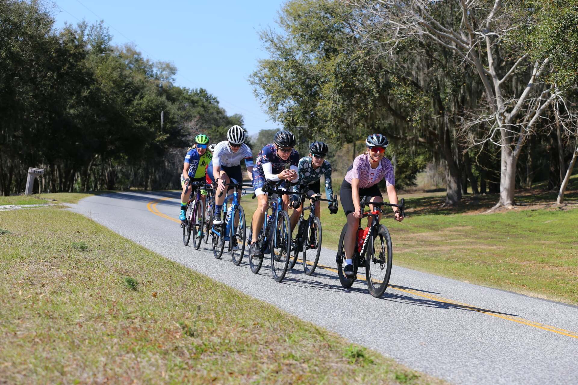 A group of people are riding bicycles down a path.
