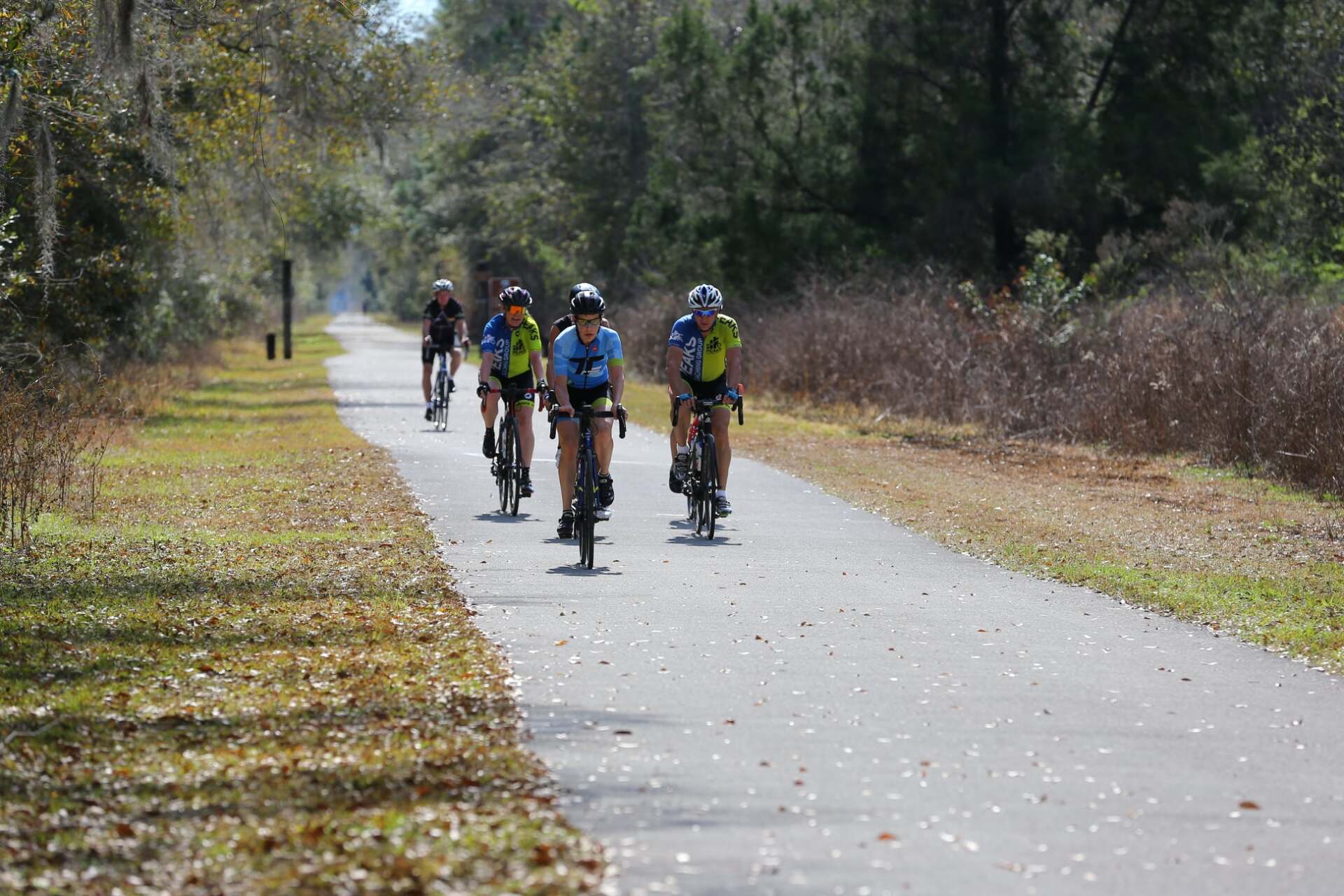 A group of people are riding bicycles down a path.