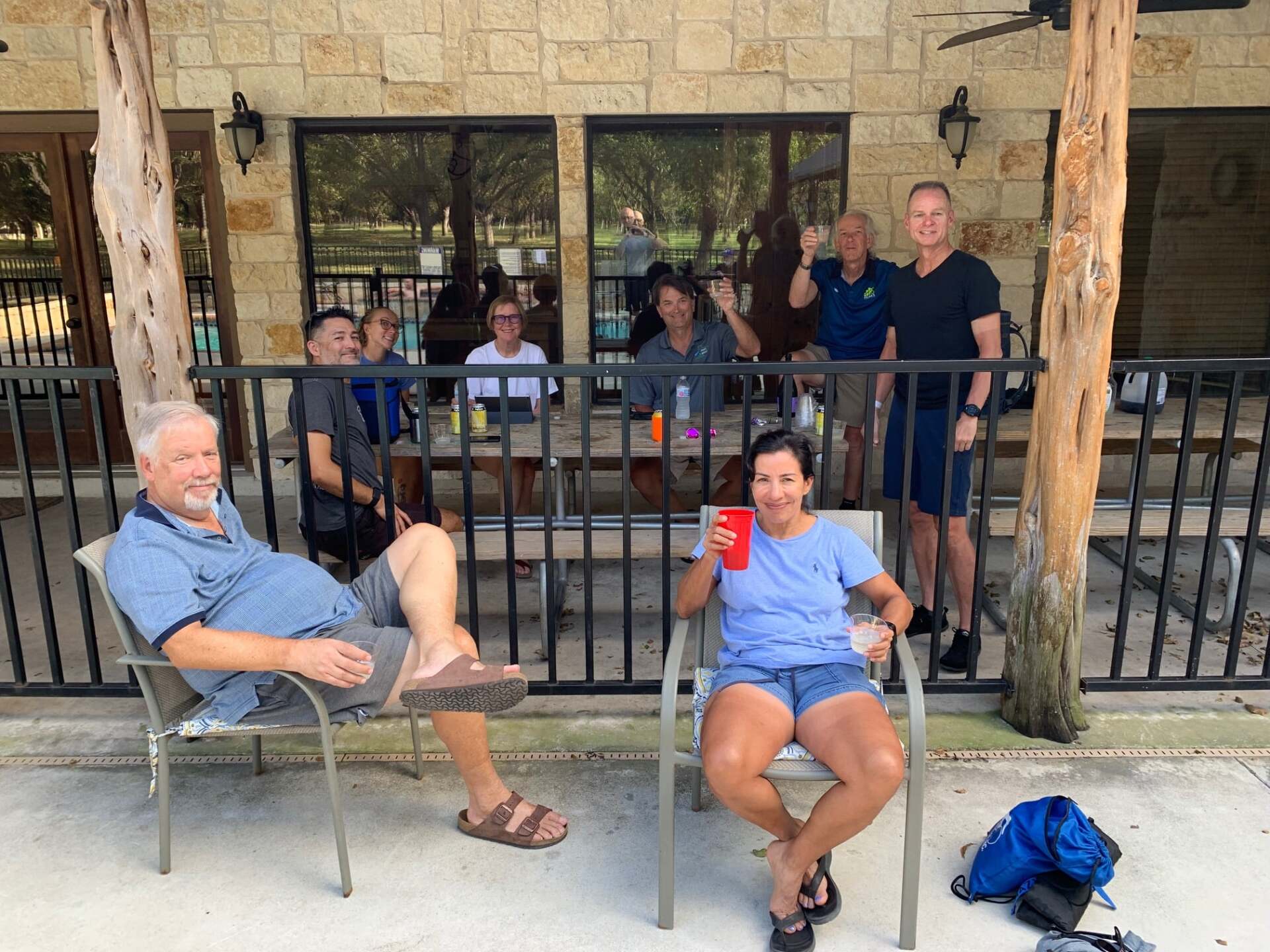 A group of people are sitting in chairs on a porch.