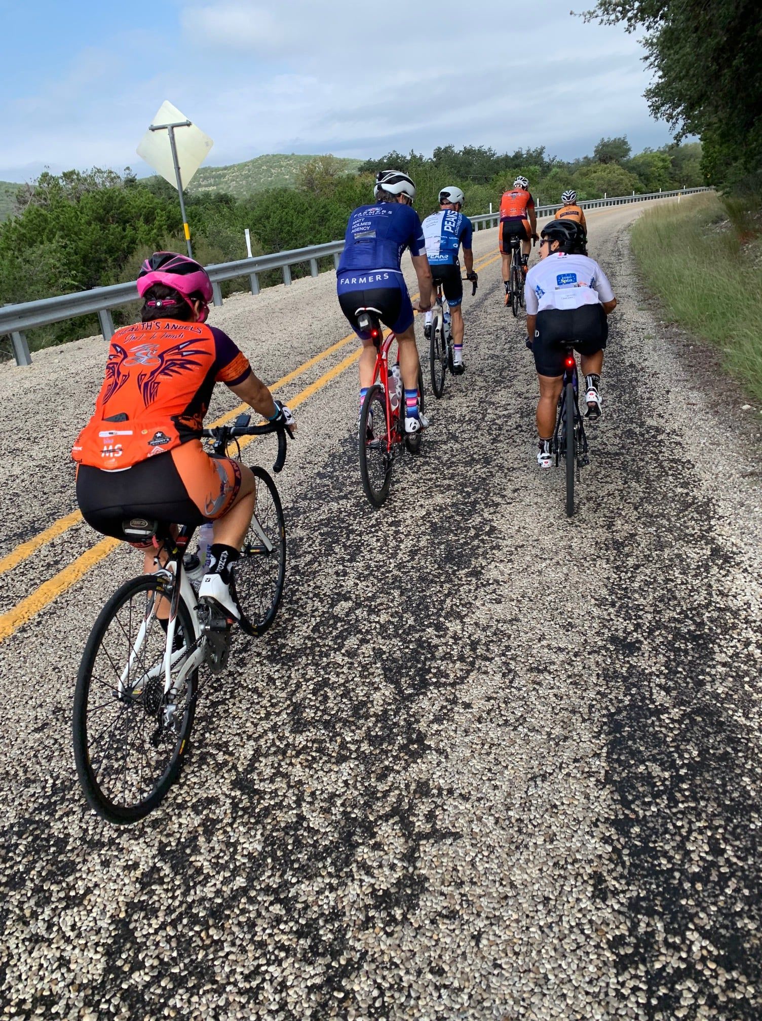 A group of people are riding bicycles down a dirt road.