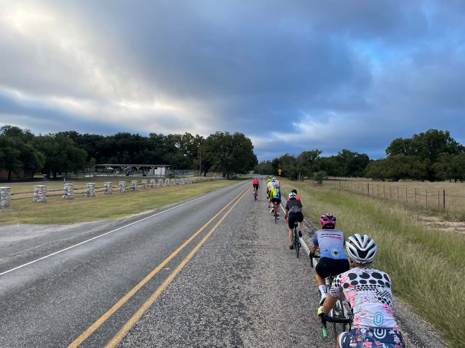 A group of people are riding bicycles down a dirt road.