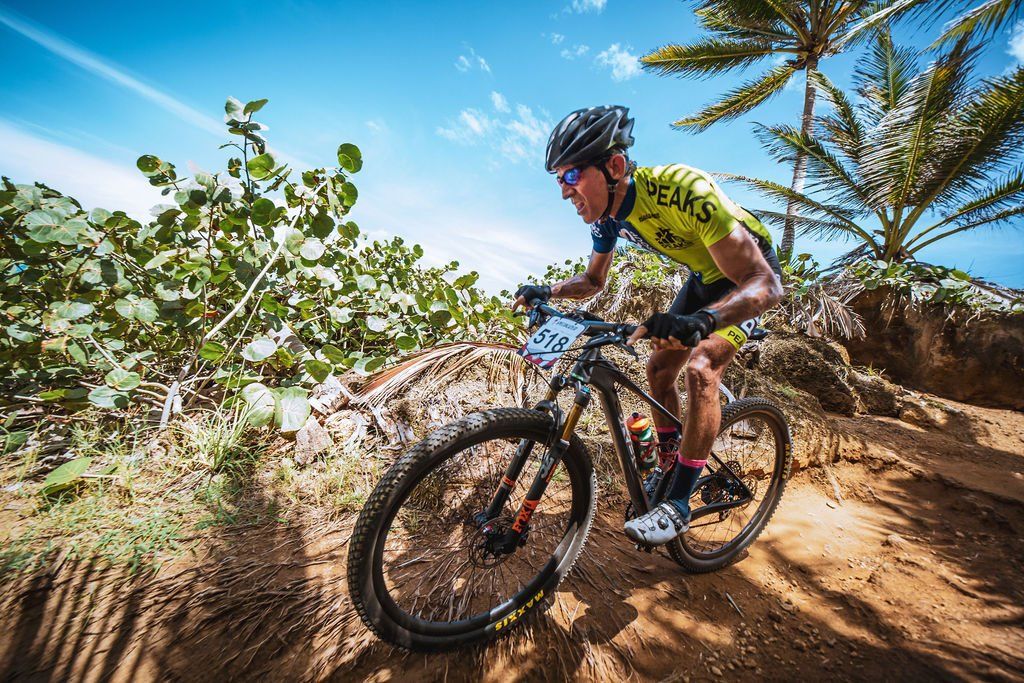 A man is riding a mountain bike down a dirt trail.