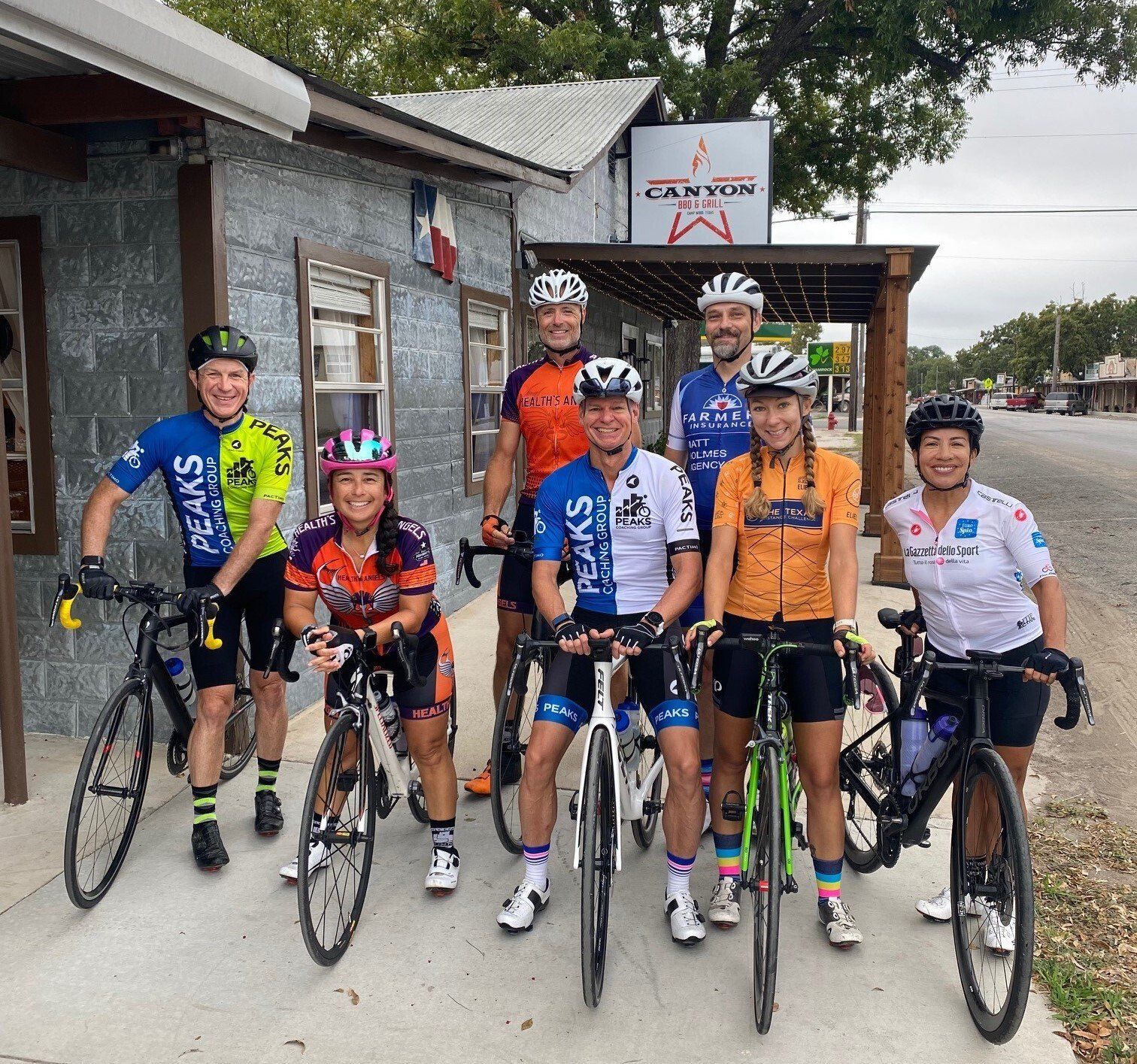 A group of cyclists are posing for a picture in front of a canyon sign