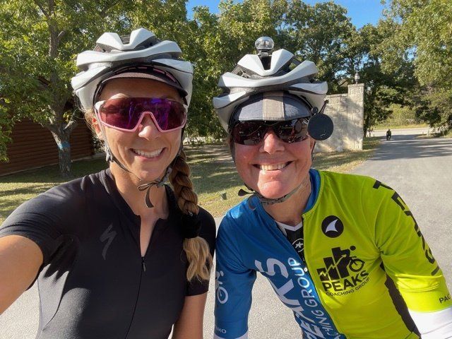 Two people wearing helmets and sunglasses are posing for a picture