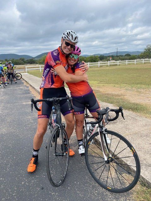 A man and a woman hugging next to bicycles