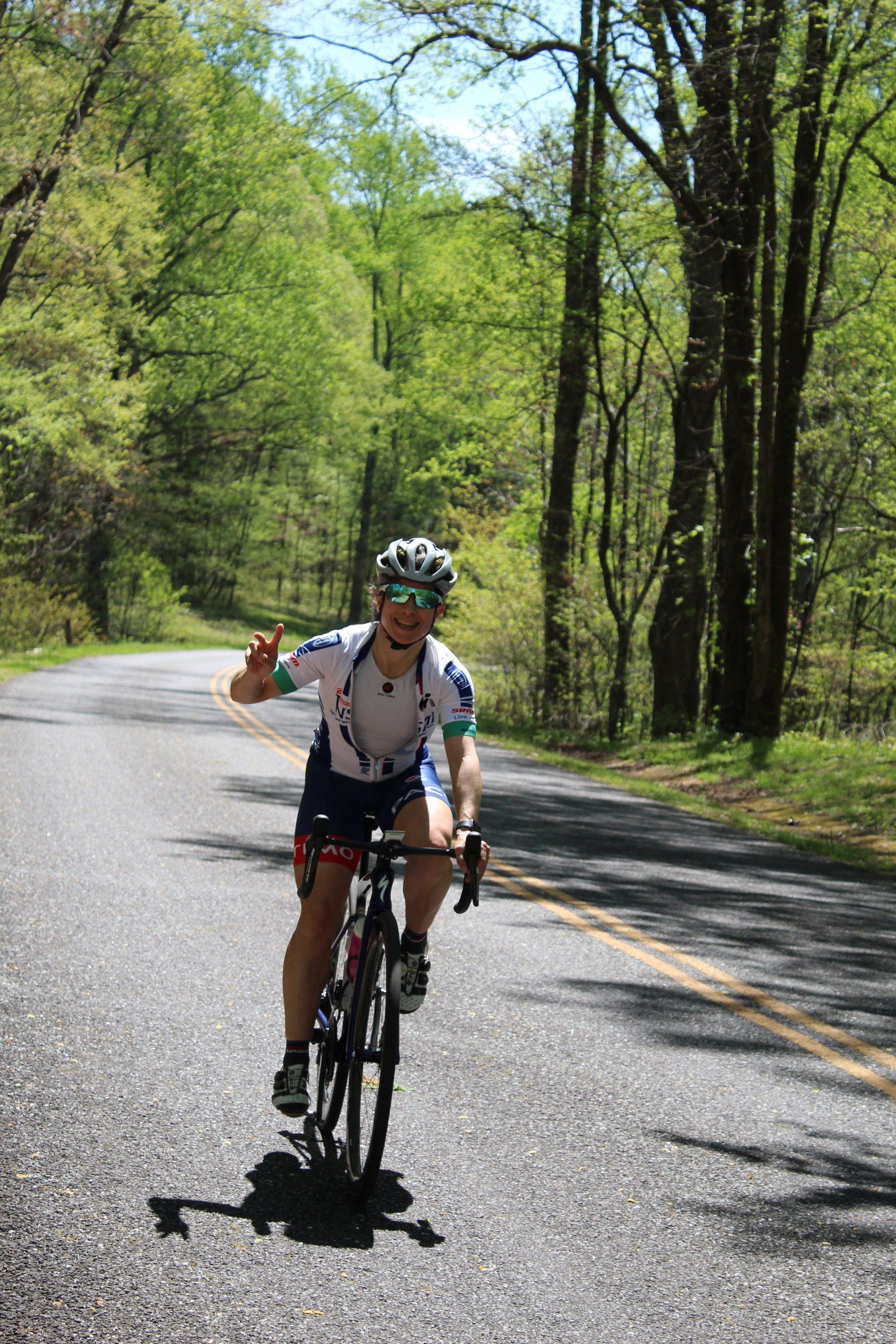 A man is riding a bike down a country road.