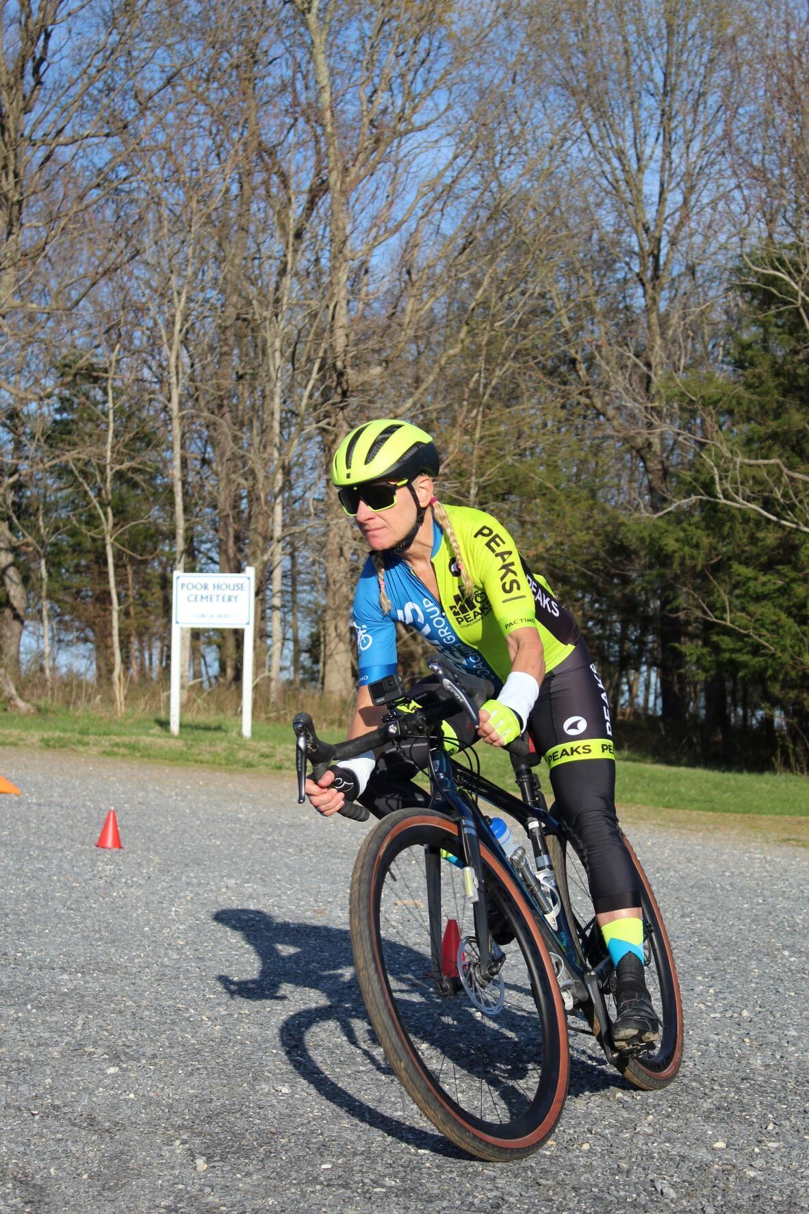 A man is riding a bike on a gravel road.