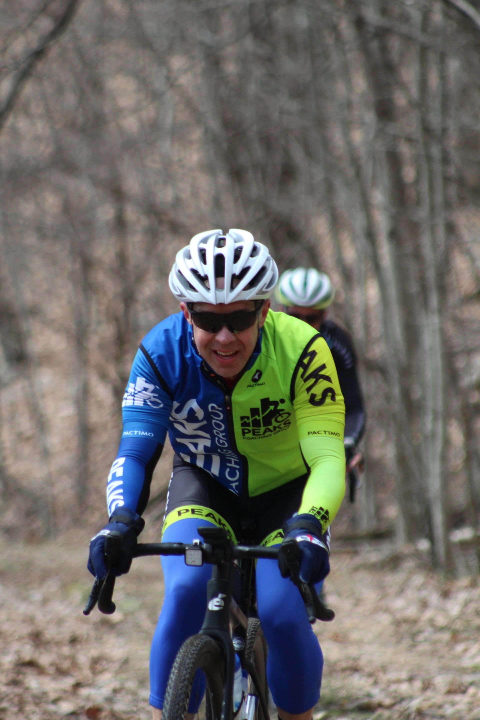A man wearing a helmet and sunglasses is riding a bike on a trail.
