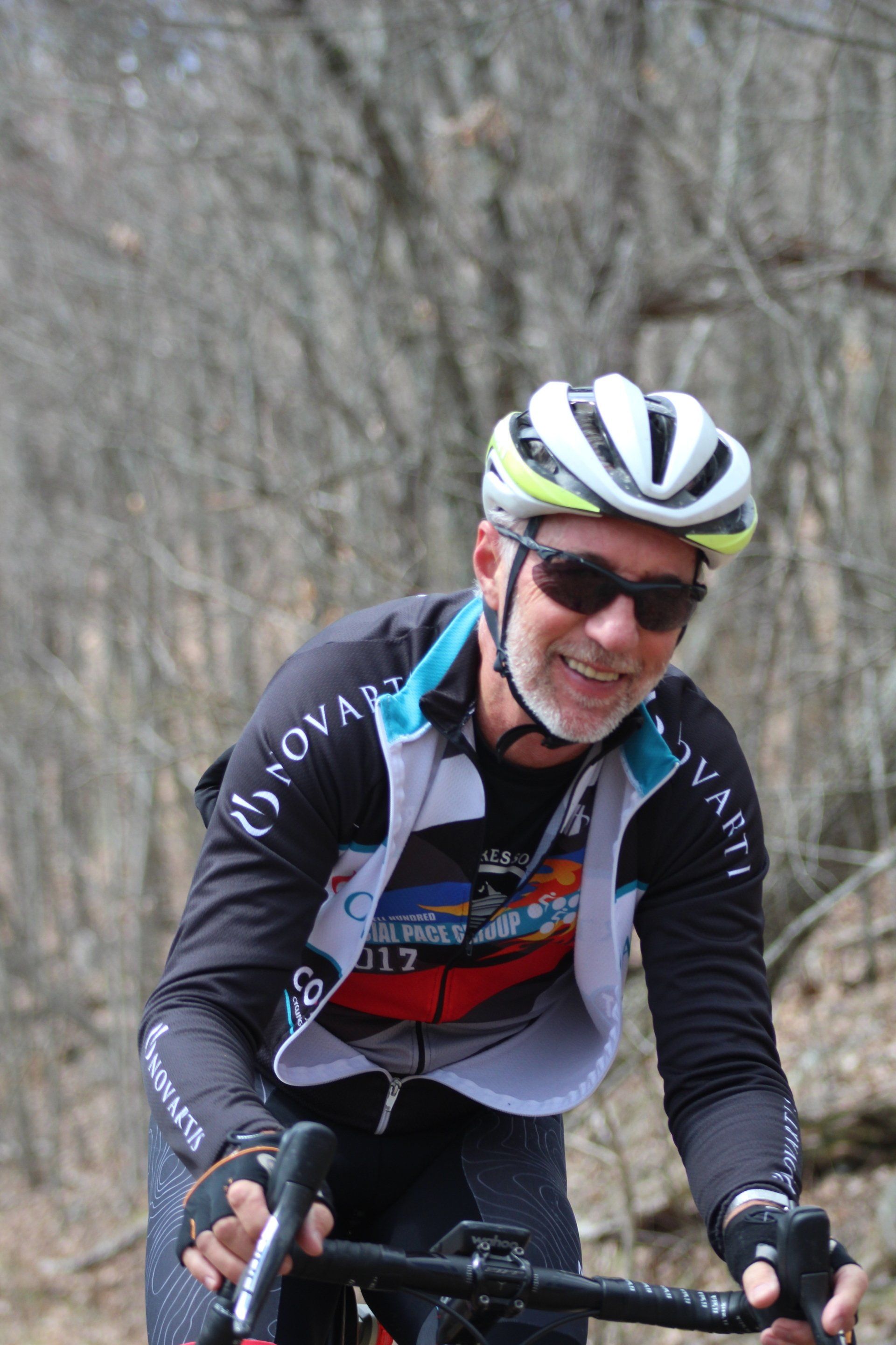 A man wearing a helmet and sunglasses is riding a bike.