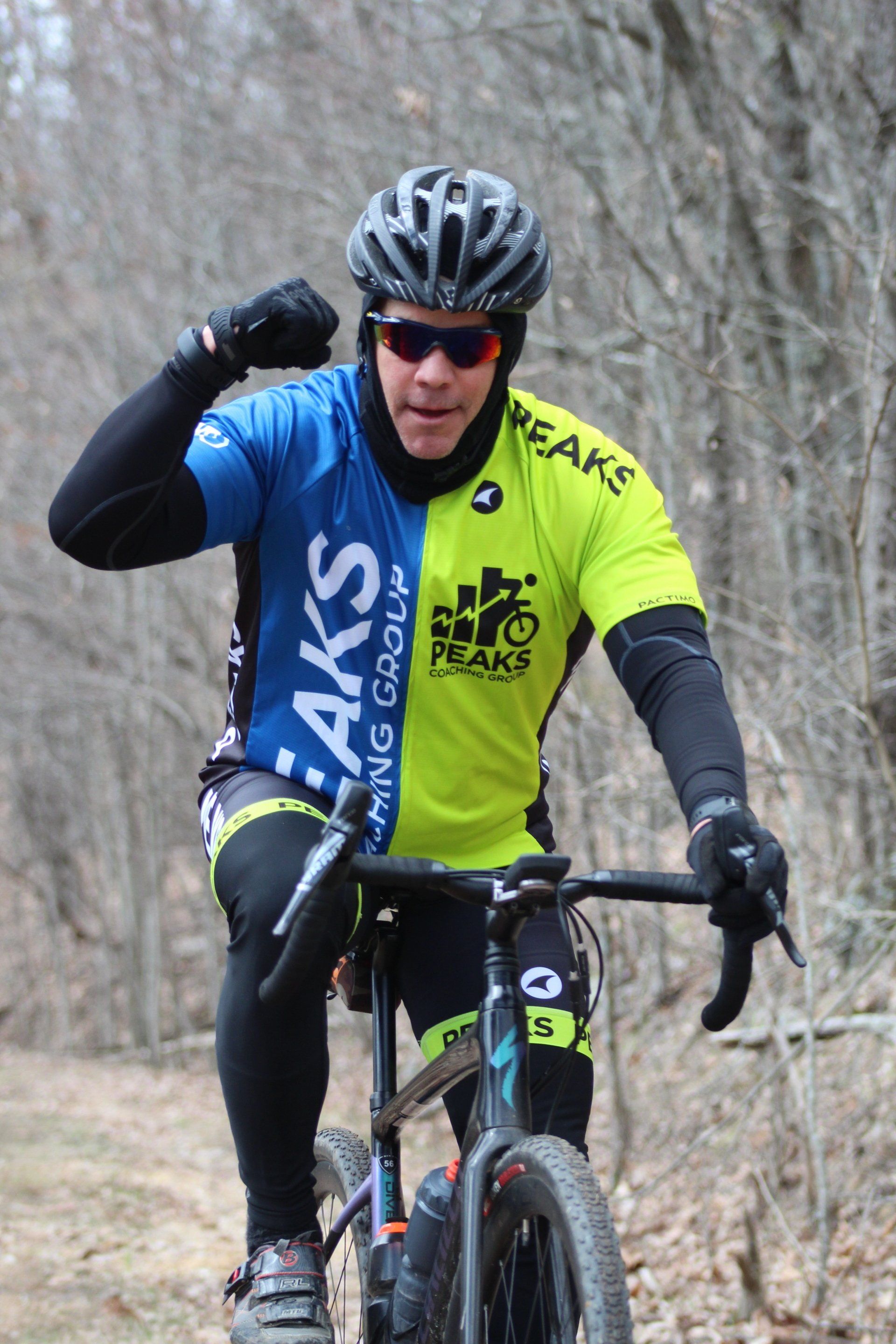 A man is riding a bike on a trail in the woods.
