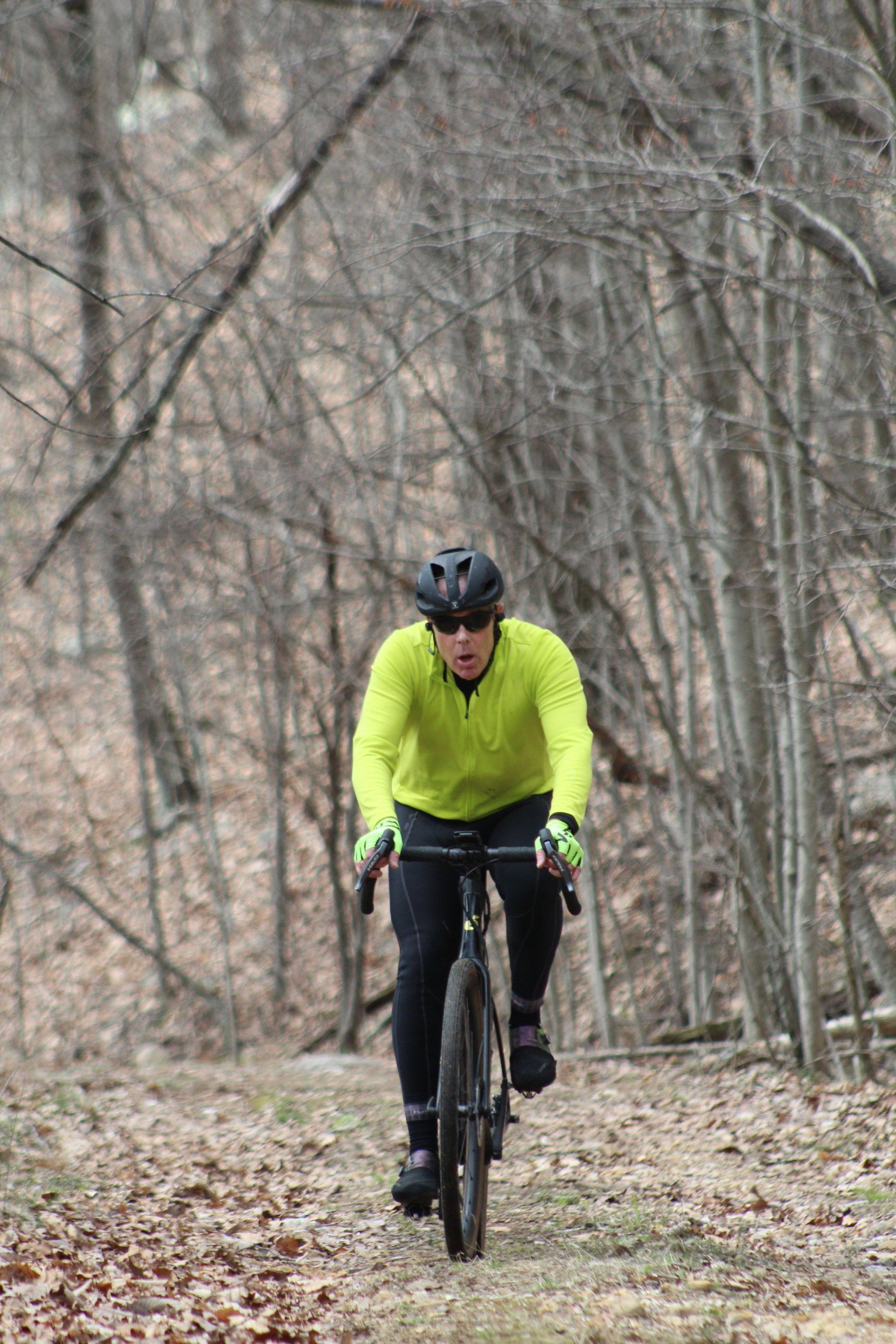 A man is riding a bike on a trail in the woods.