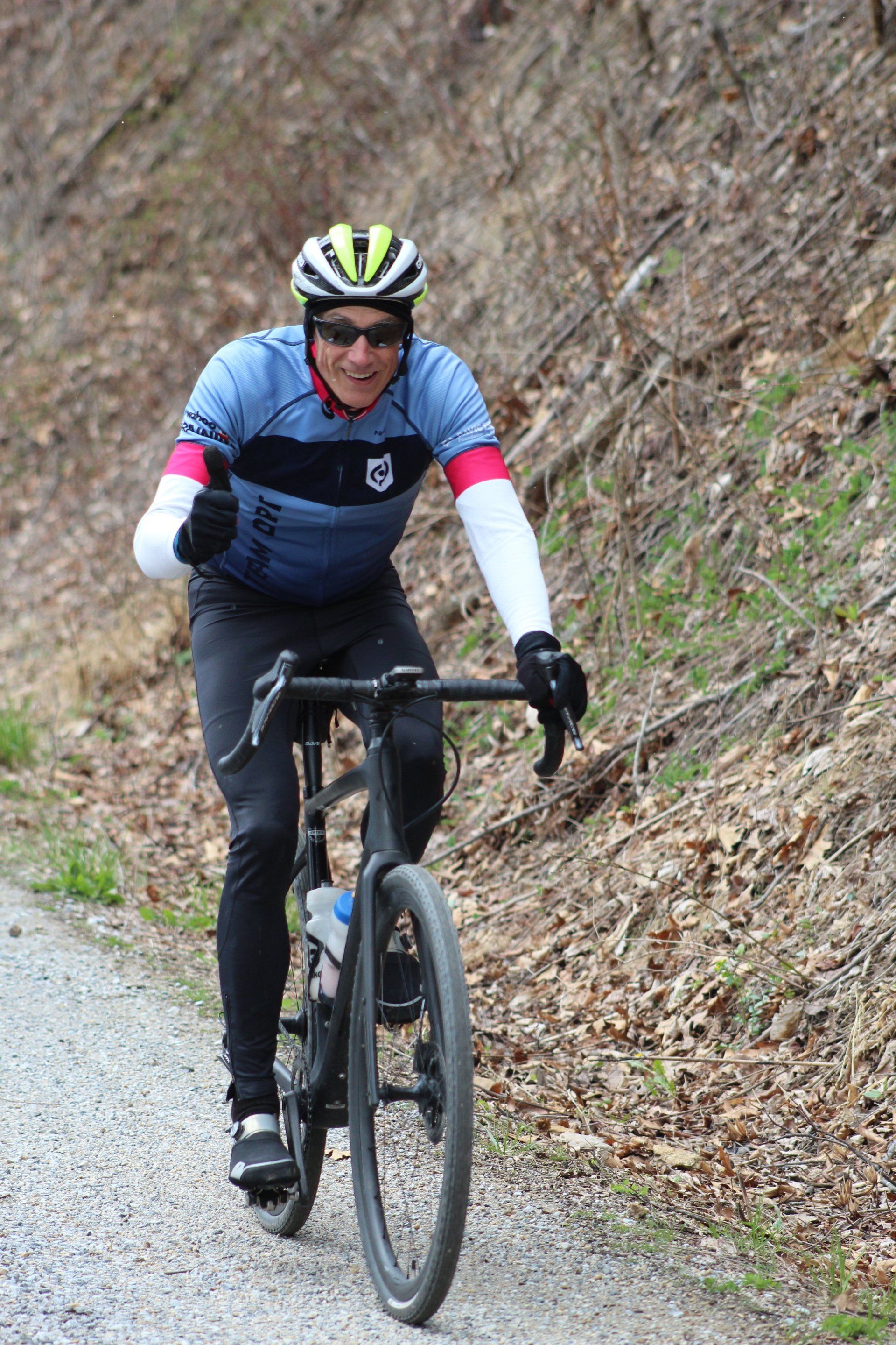 A man is riding a bike down a dirt road.