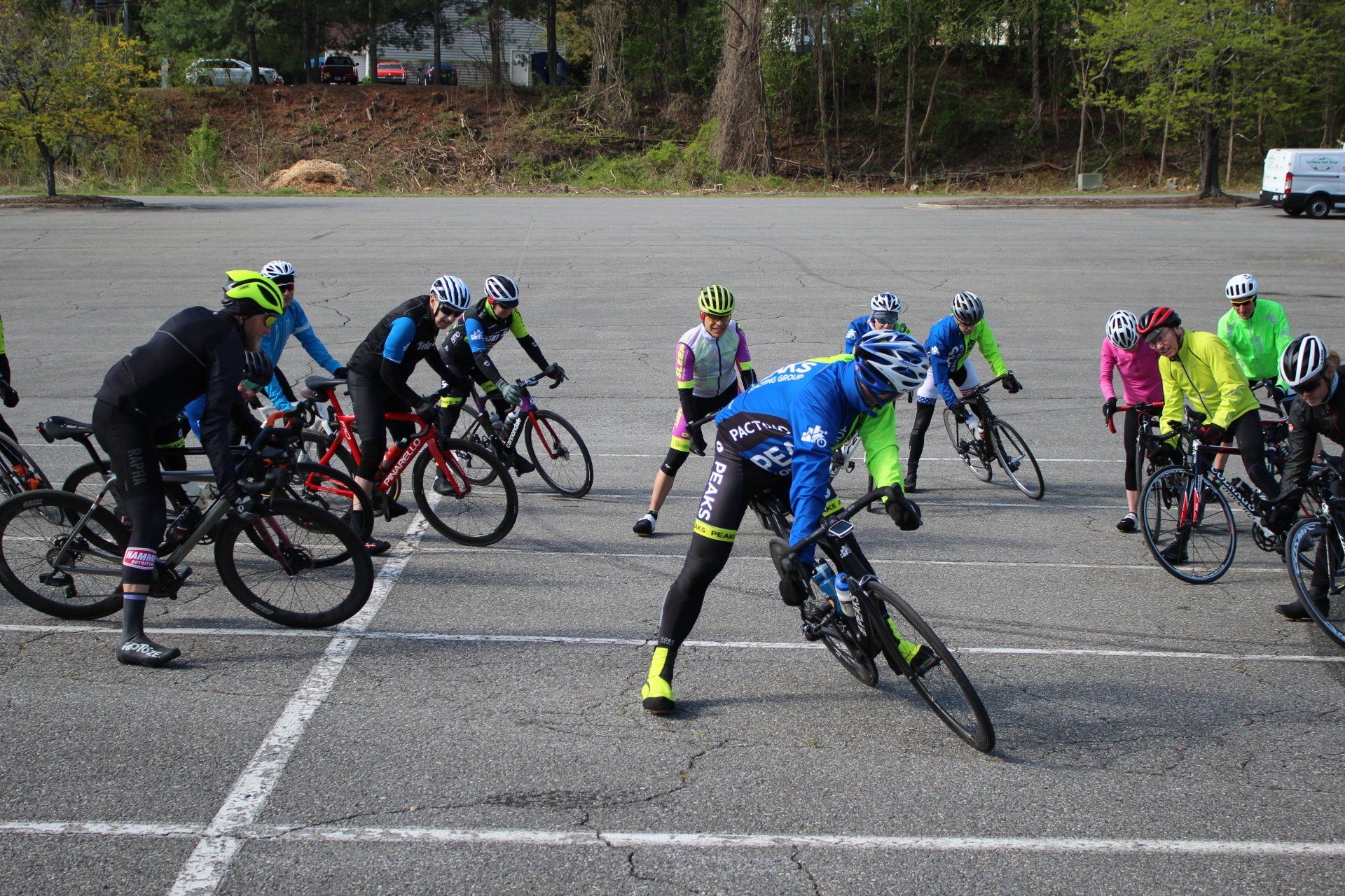A group of people are riding bicycles in a parking lot.