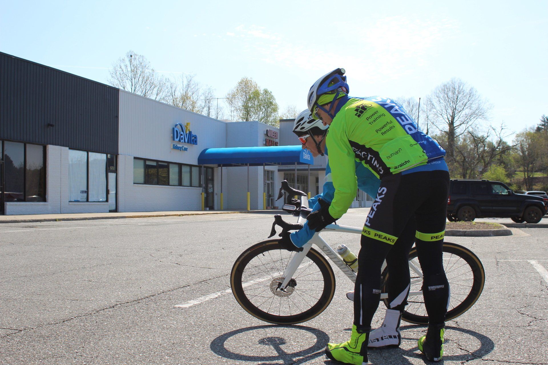 A man is standing next to a bicycle in front of a building.