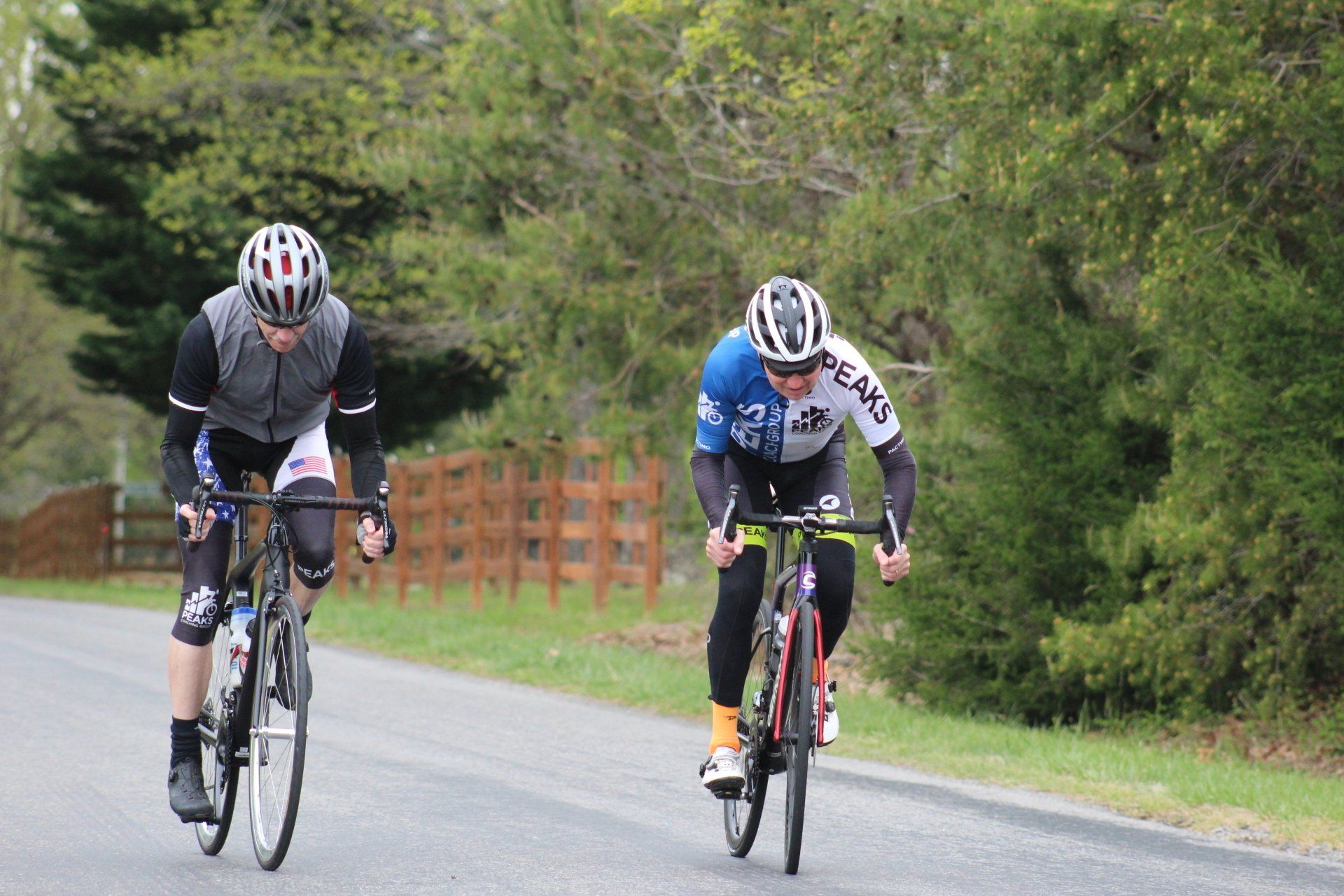Two men are riding bicycles down a road.