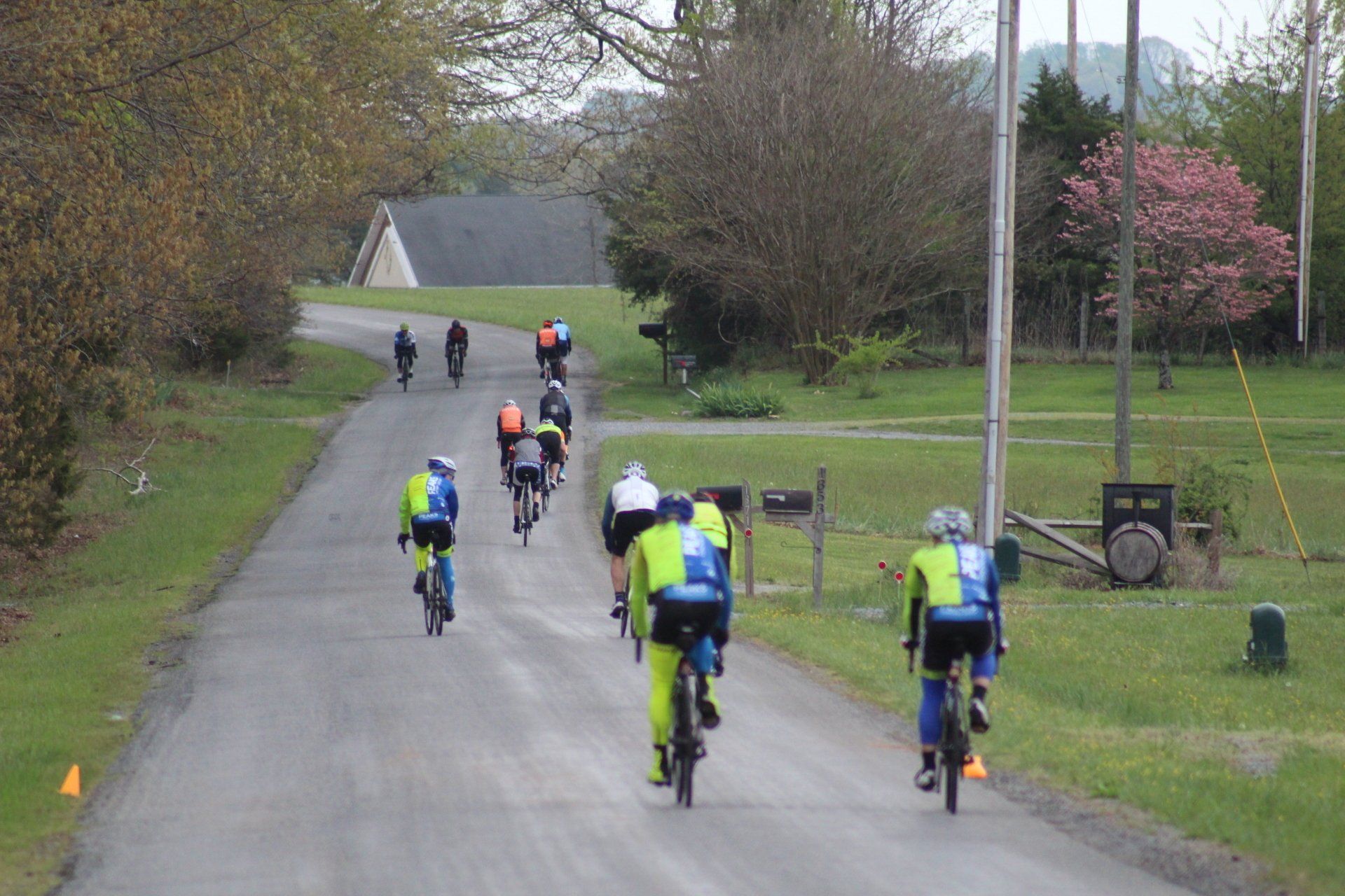 A group of people are riding bicycles down a dirt road.