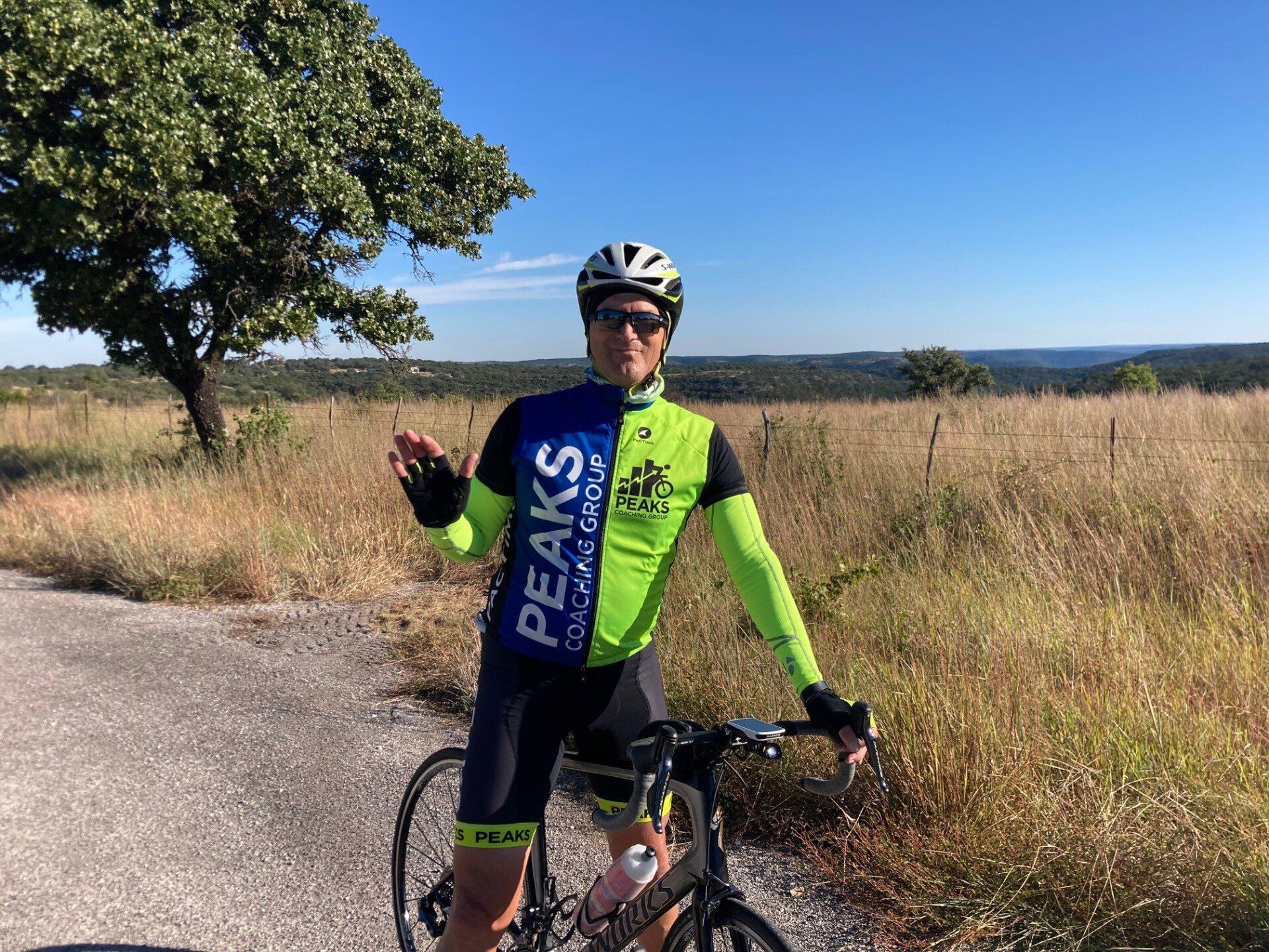 A man is standing next to a bicycle on a dirt road.