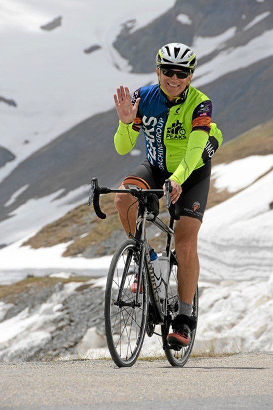 A man riding a bike wearing a shirt that says super