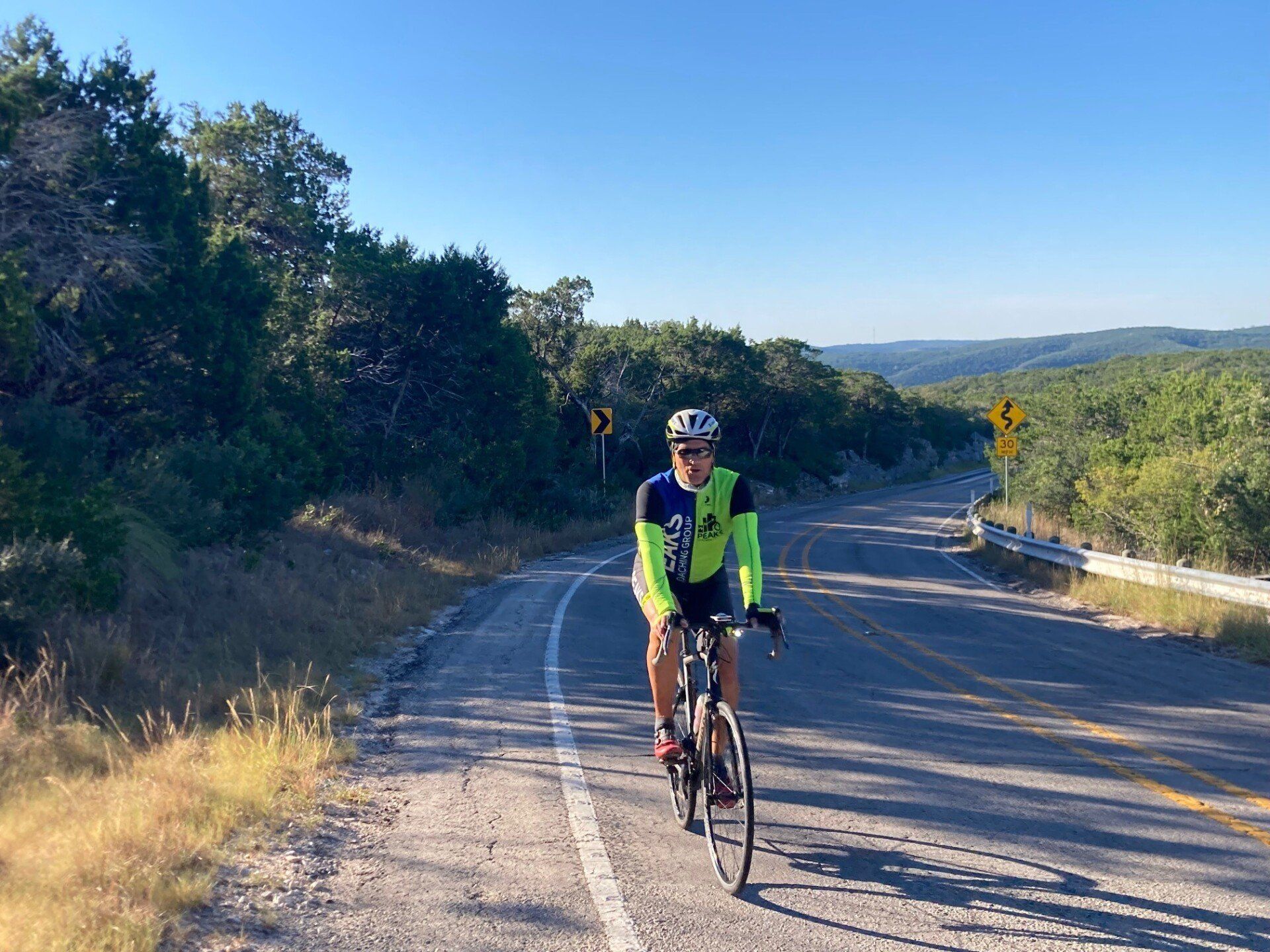 A man is riding a bike down a road.