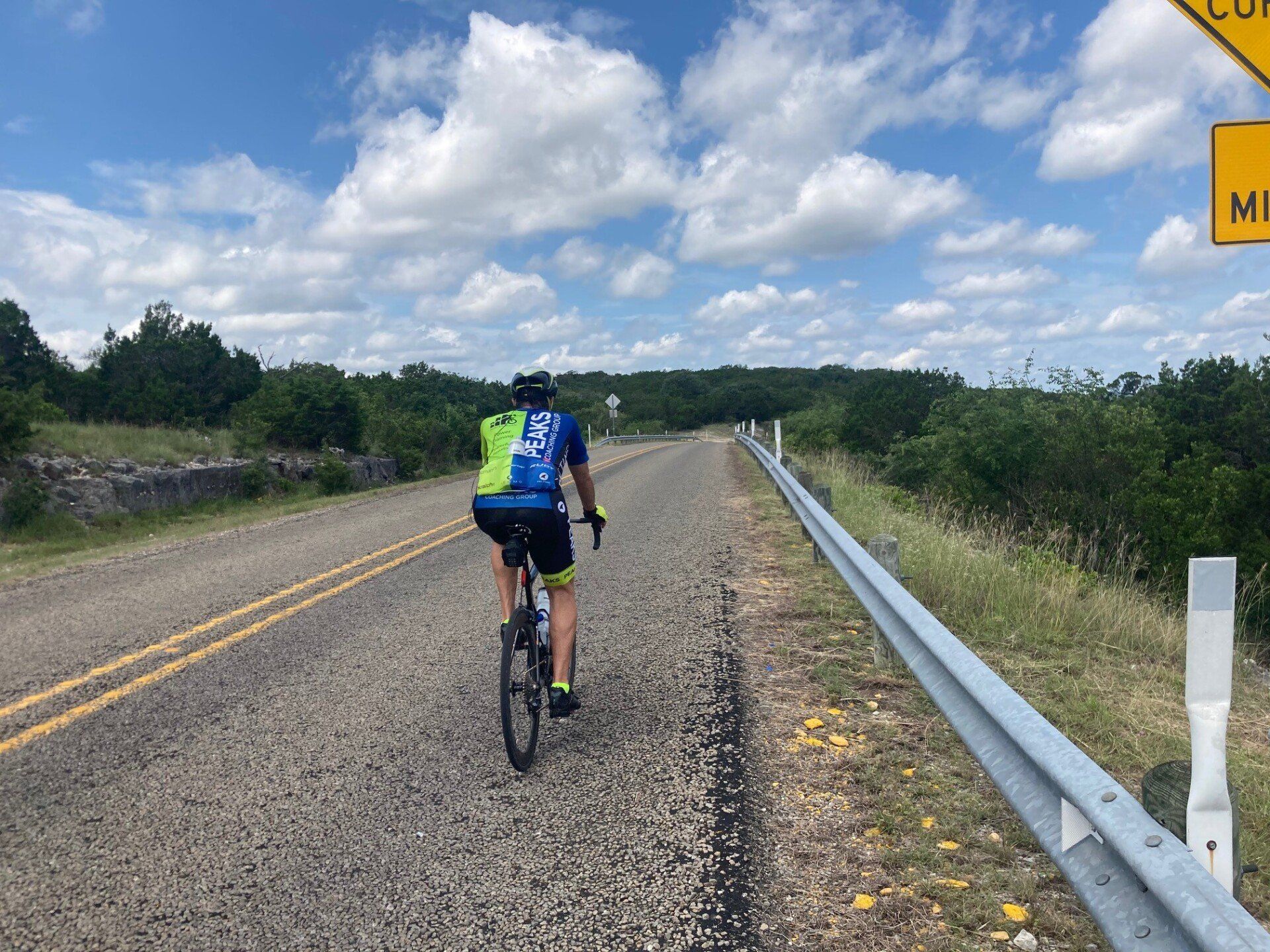 A person is riding a bike down a road next to a yellow sign that says highway