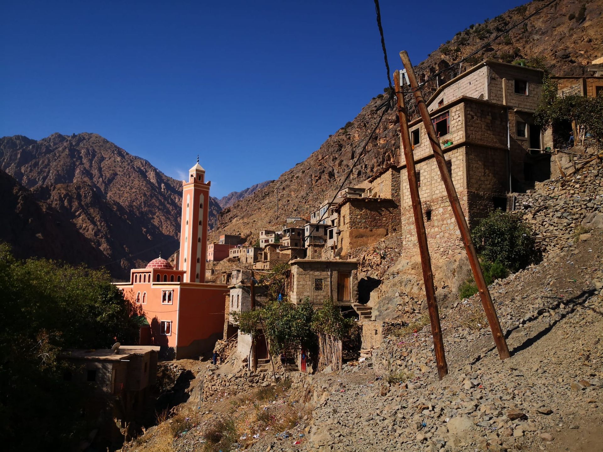 A building in the middle of a valley with mountains in the background