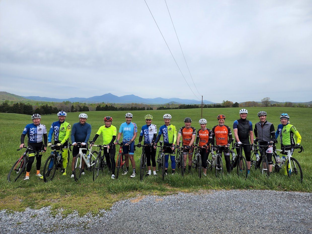 A group of people standing next to each other on bicycles in a field.