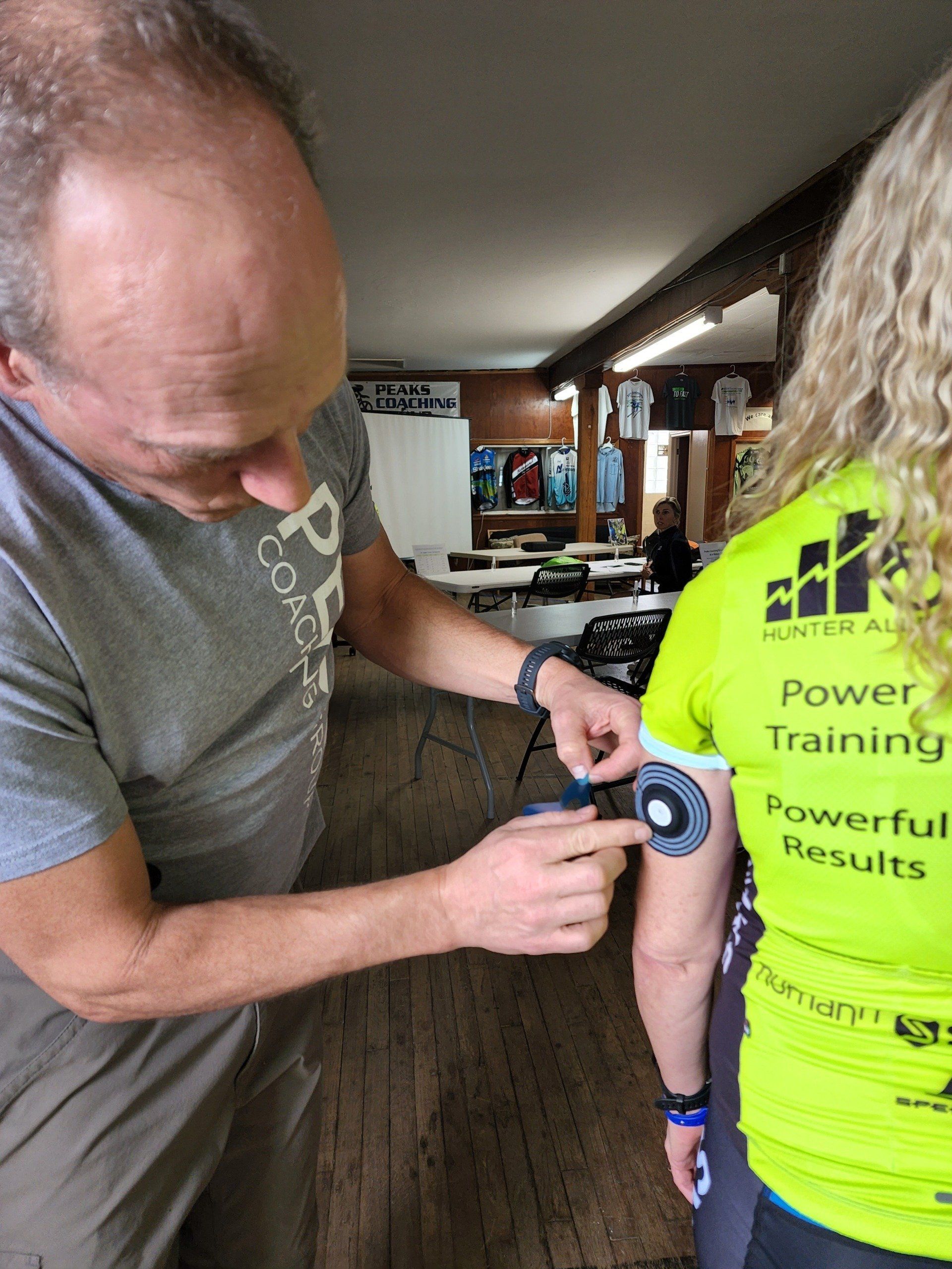 A man is measuring a woman 's arm with a tape measure.