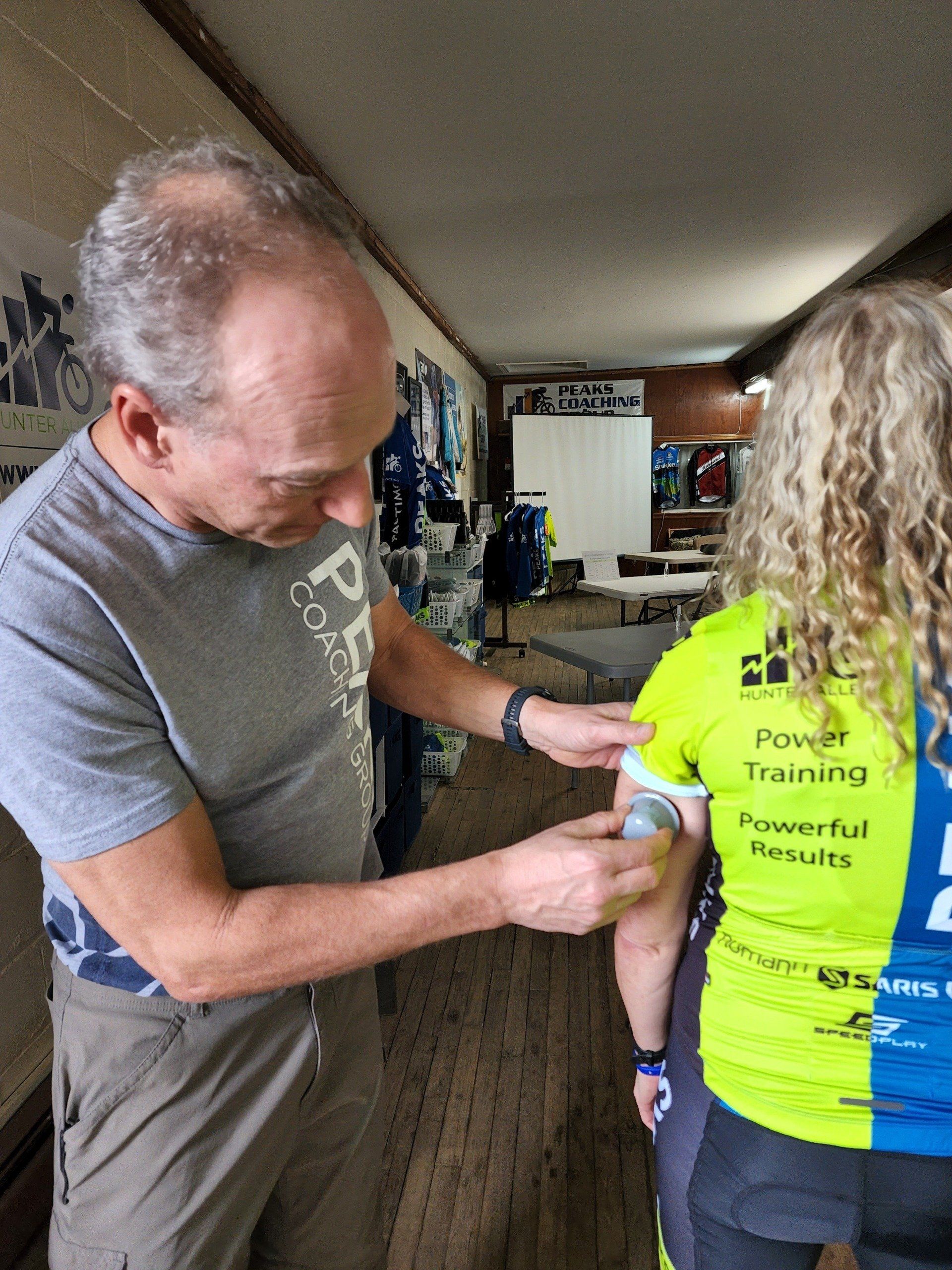 A man is putting a bandage on a woman 's arm.