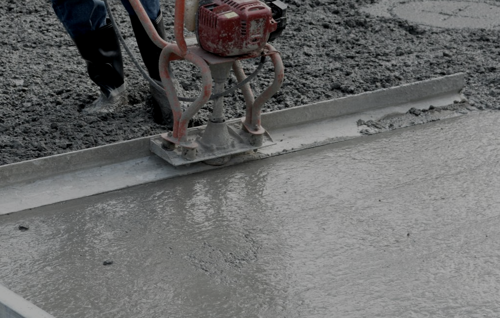 Concrete resurfacing equipment restoring worn residential driveway surface