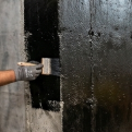Basement repair technicians sealing visible wall cracks inside residential property