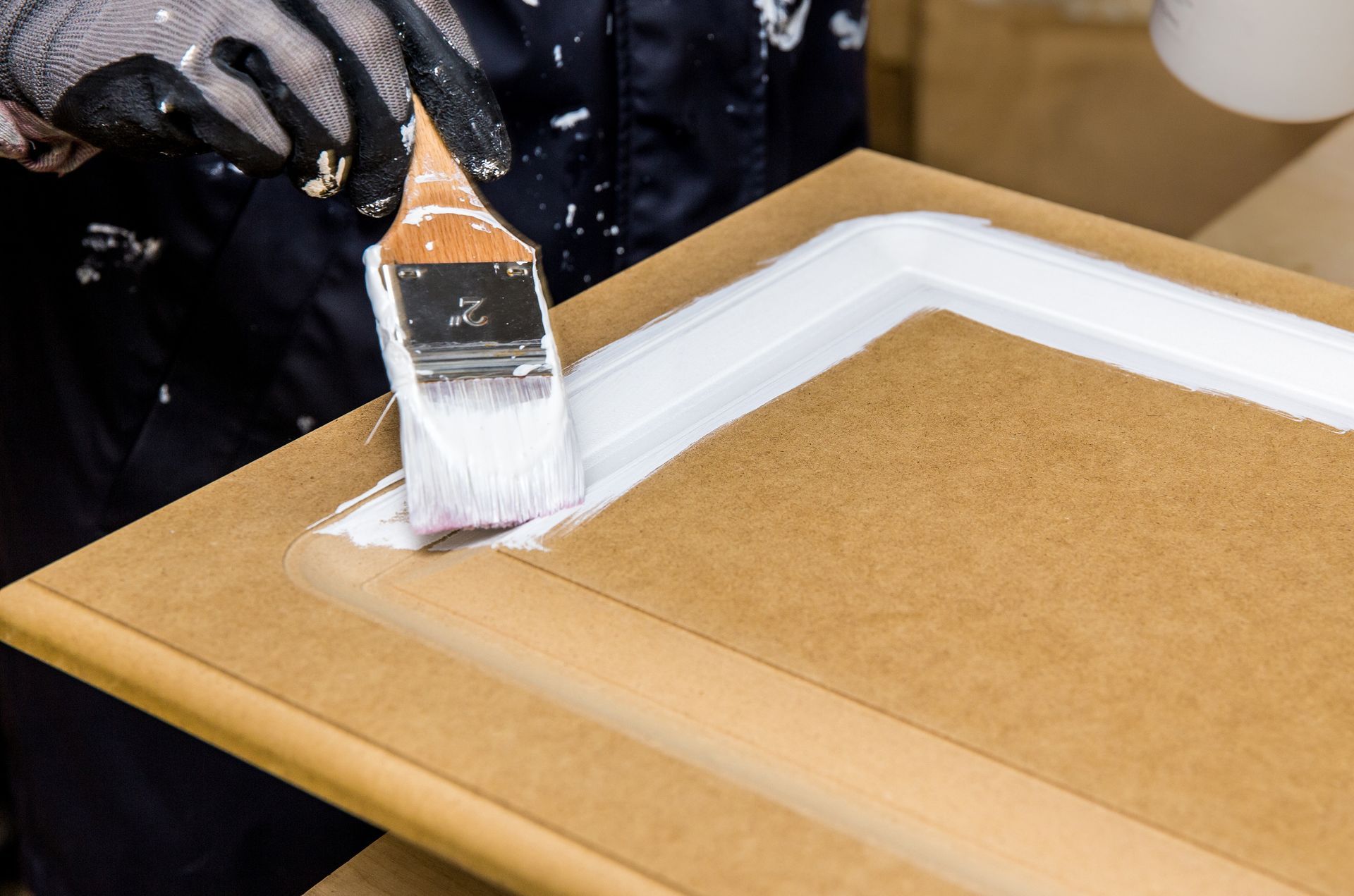 A person is painting a piece of wood with a brush.