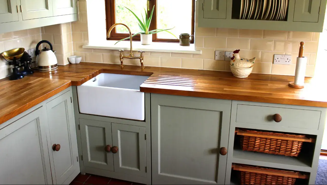 A kitchen with a white sink and wooden counter tops.
