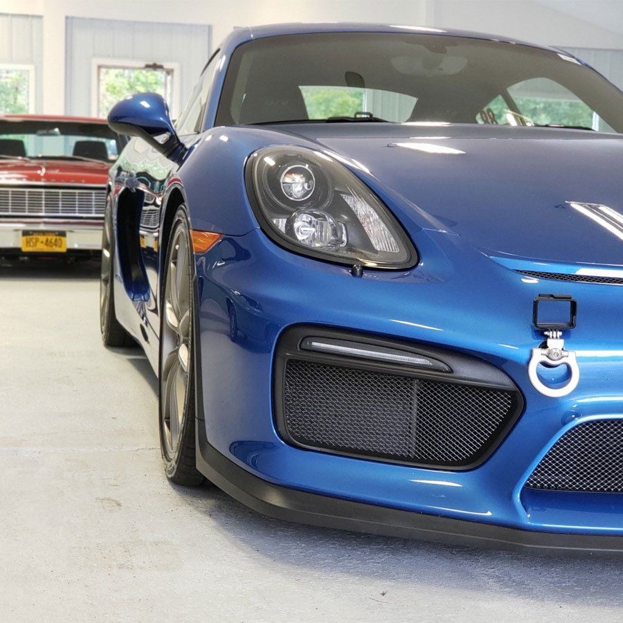 A blue sports car is parked in a garage