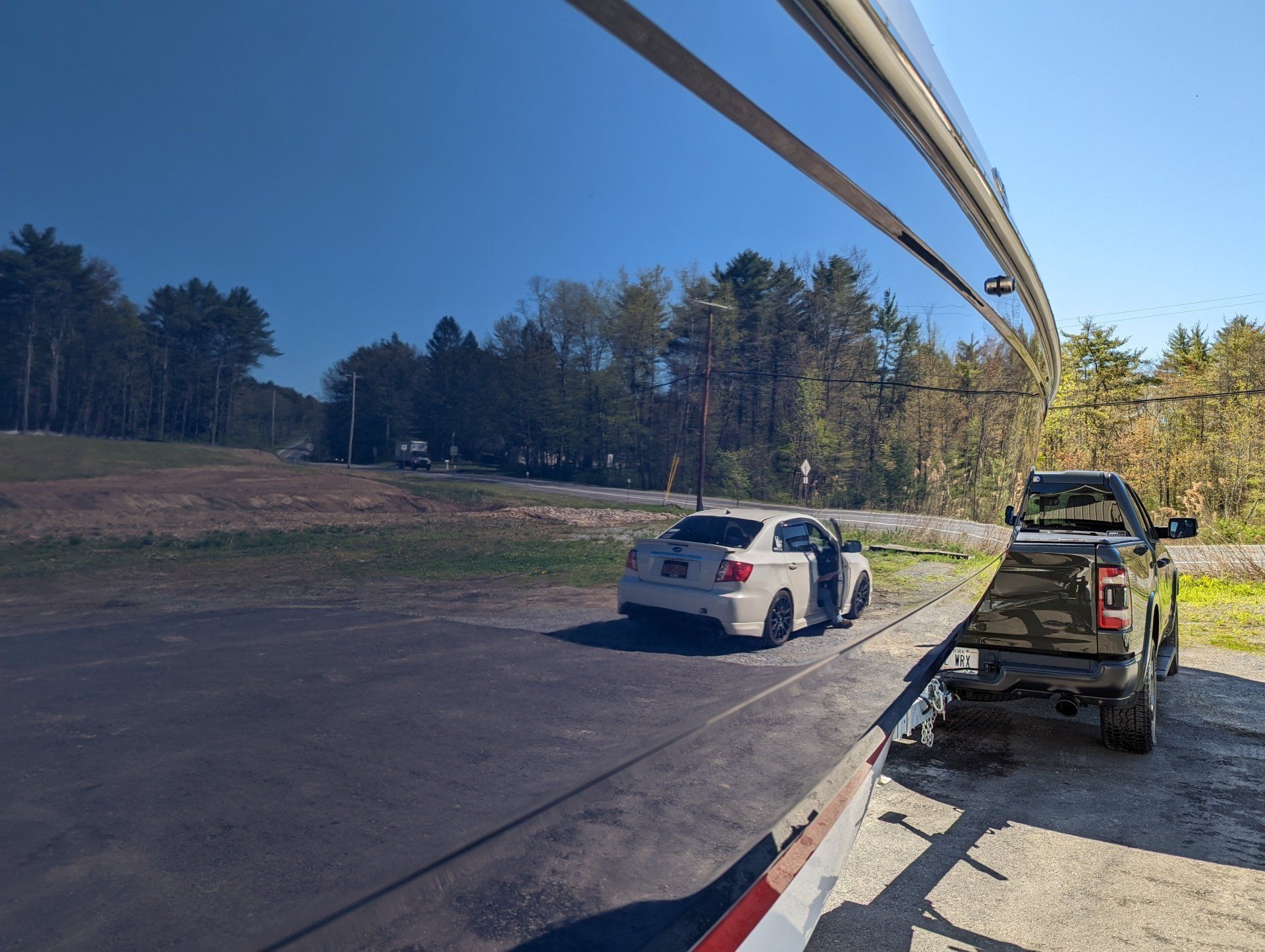 A car is being towed by a truck in a parking lot.