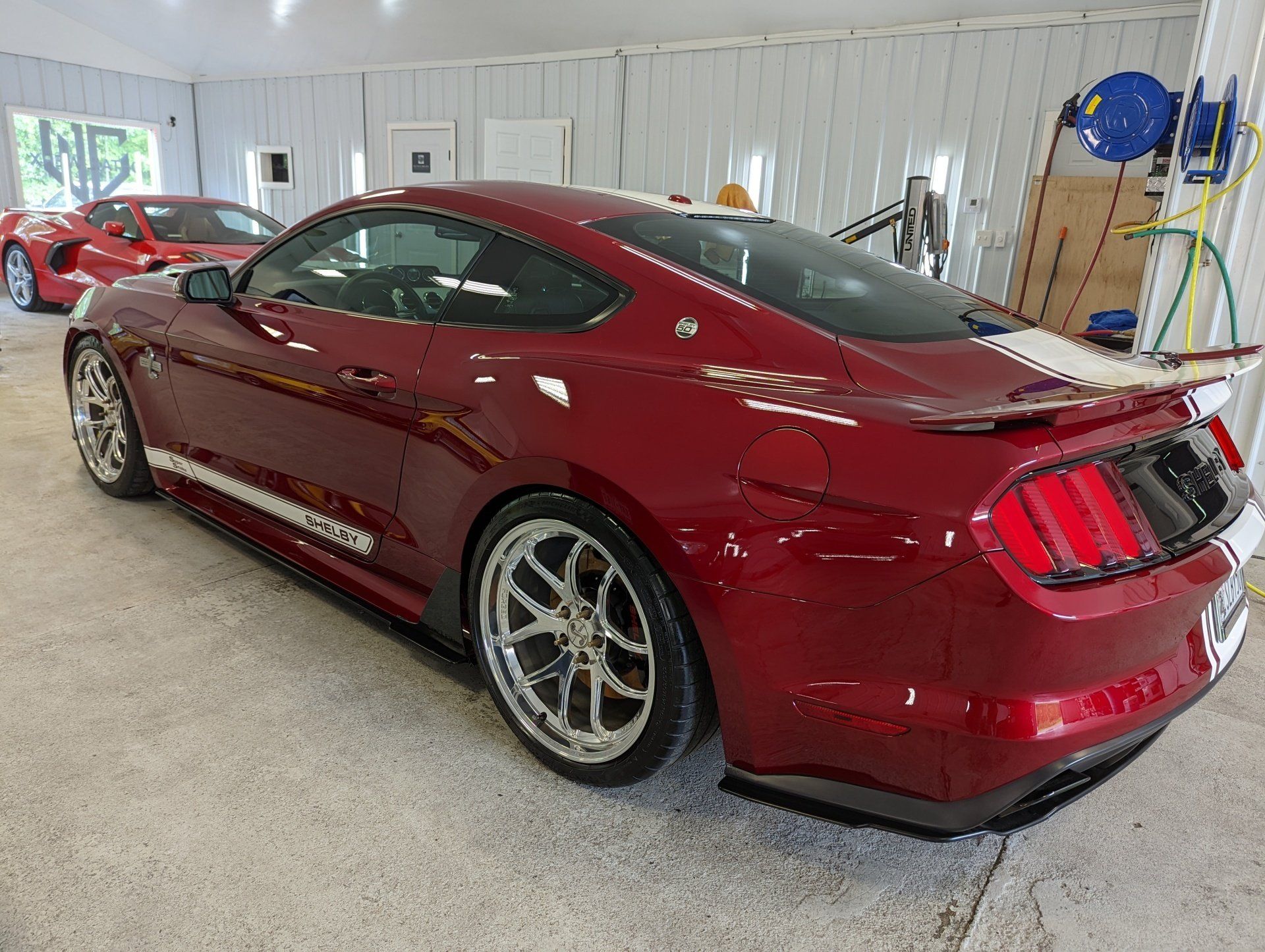 A red ford mustang is parked in a garage.