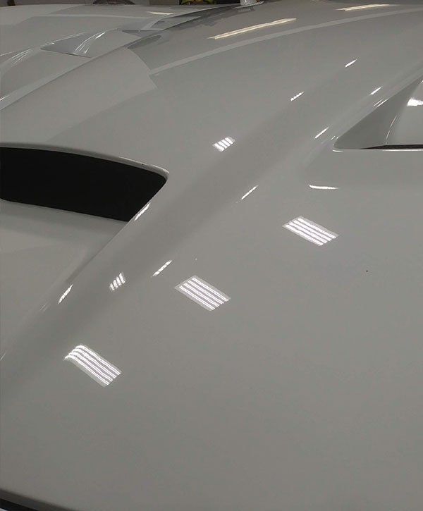 A close up of the hood of a white car.