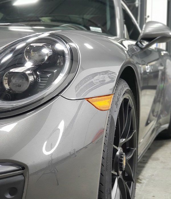 A close up of a car 's headlight and tire