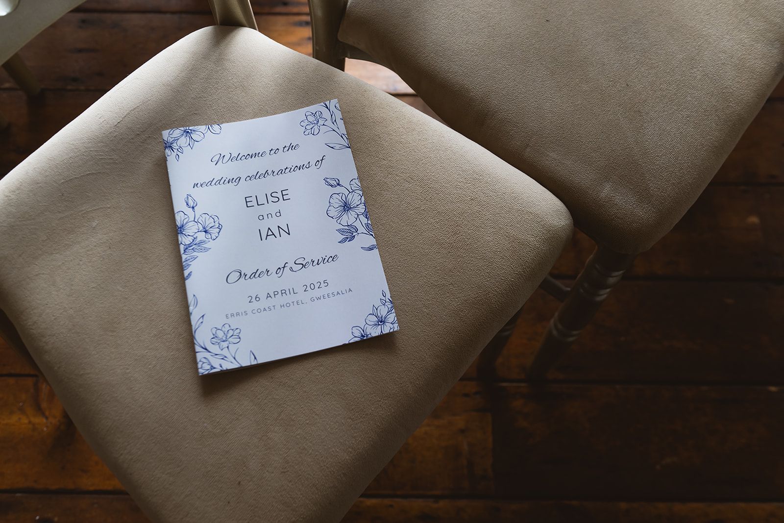 Notebook with handwritten notes resting on a beige upholstered chair near a wooden floor.