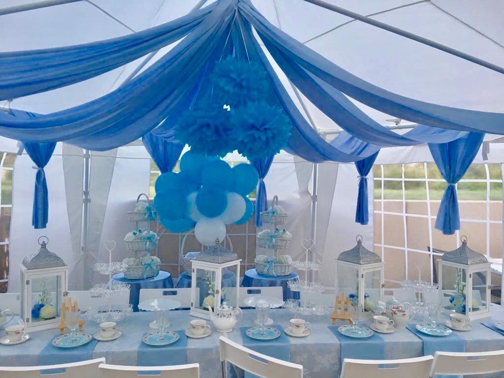 Blue and white party dessert table under draped canopy, with matching decorations and cakes