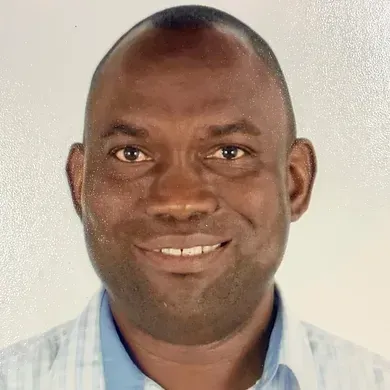Smiling man in a light blue shirt against a plain background