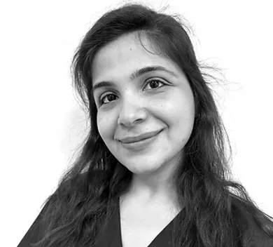 Smiling person with long dark hair against a plain white background