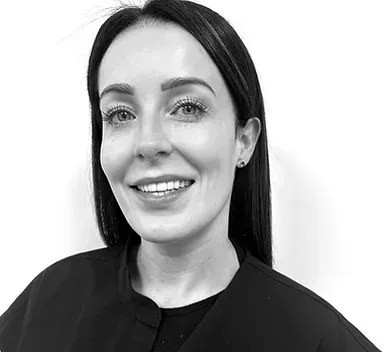 Black-and-white portrait of a smiling woman with dark hair against a plain background
