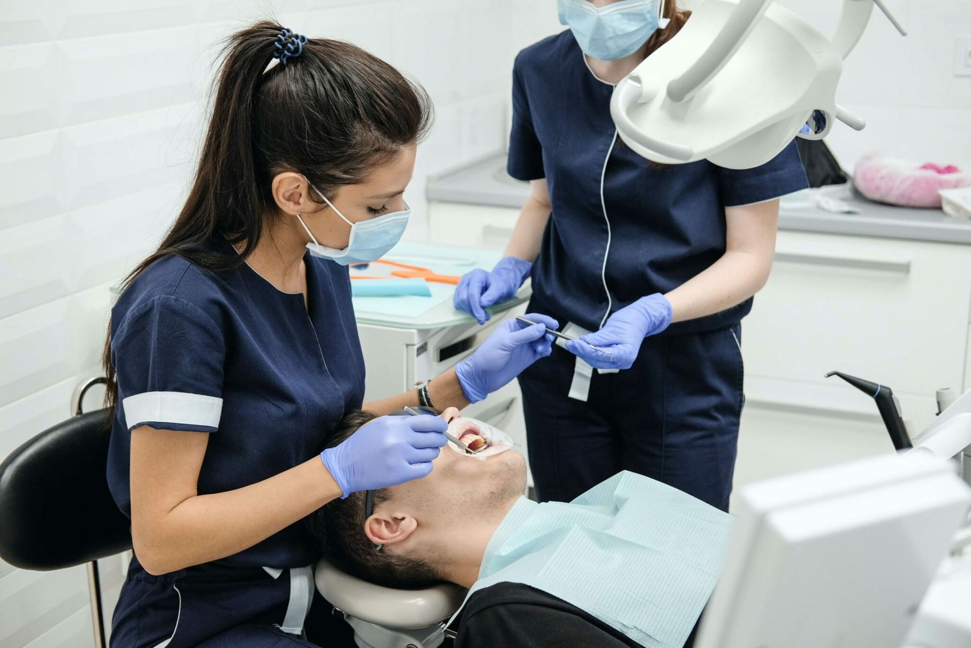 Female dentist treating a relaxed patient during a dental appointment.