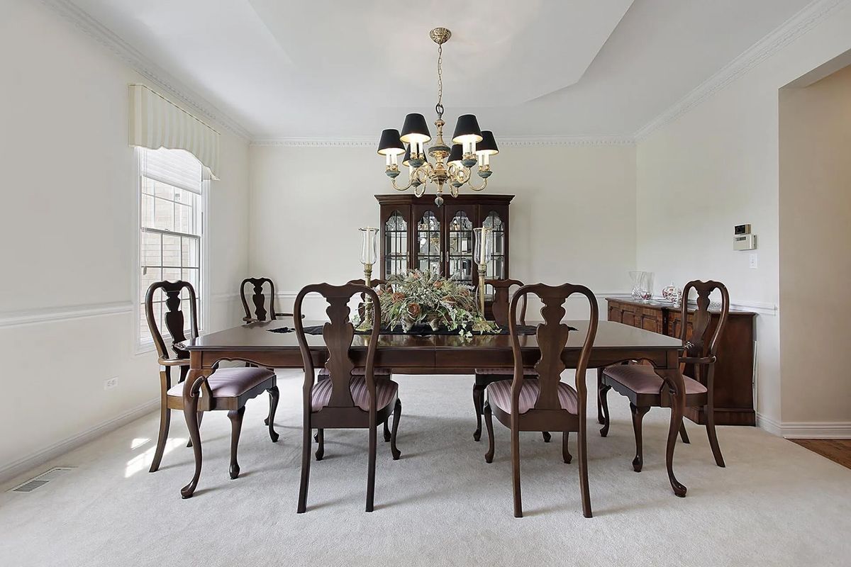 A dining room with a table and chairs and a chandelier.