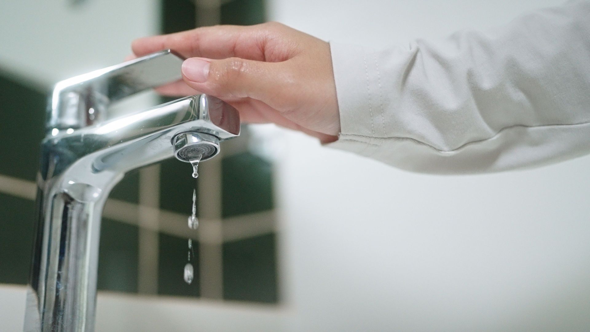 Licensed plumber repairing a kitchen sink and tap in an Adelaide home.